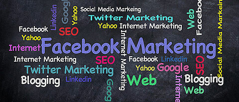 Schwarze Tafel, auf die farbige Schlagworte wie Online-Marketing, Blogging und die Namen verschiedener Social Media Kanäle geschrieben sind.