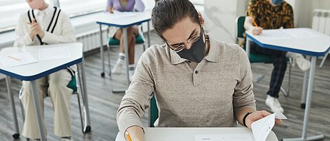 Personen schreiben Klausur mit Maske